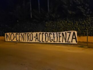 No centro accoglienza, uno striscione compare alla ex Villa, ma qualcuno lo ha strappato